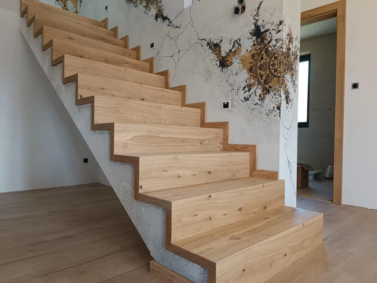 Concrete staircase clad in solid rustic oak treads and risers