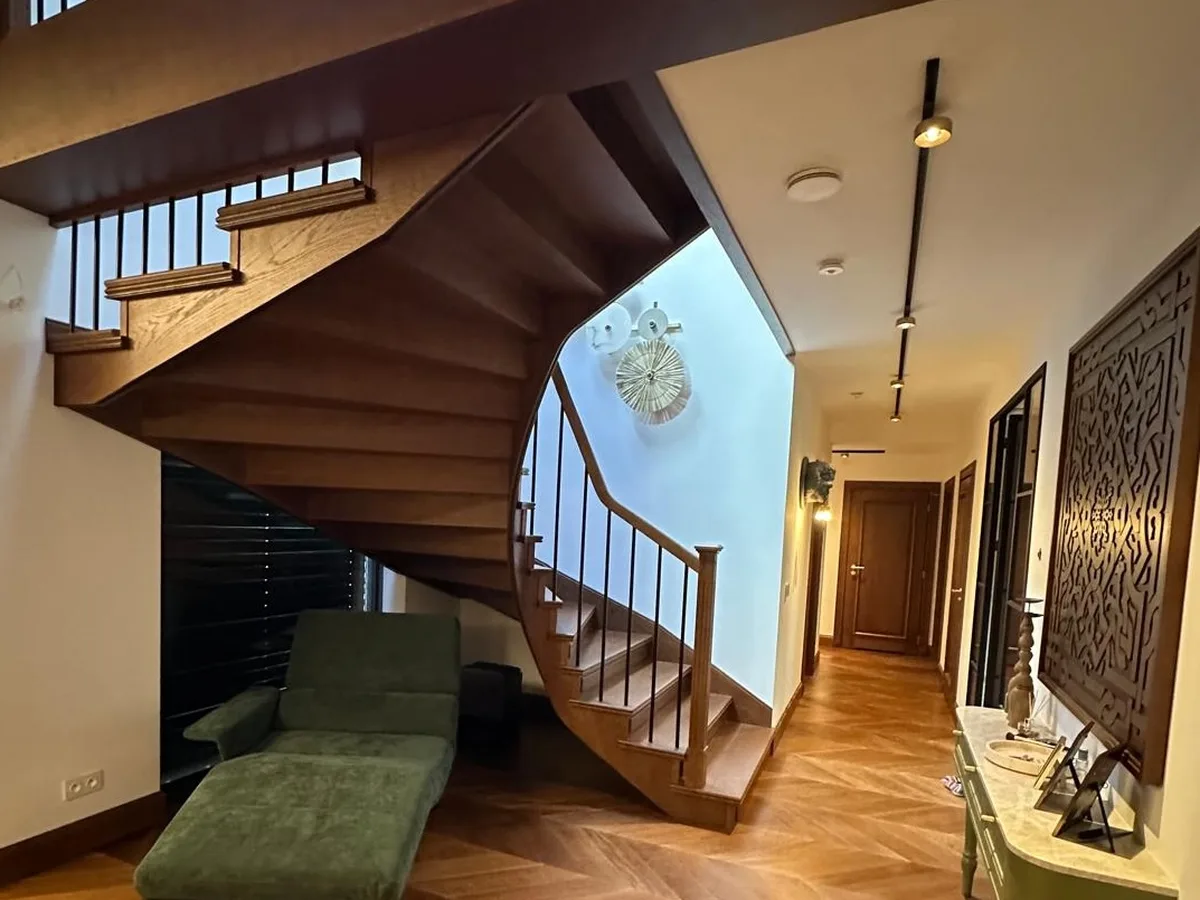 Oak staircase with LED-lit treads and a frameless glass balustrade